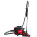 A Sanitaire canister vacuum cleaner with a red and black handle.