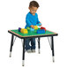 A child playing with blocks on a Jonti-Craft preschool table.