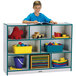 A boy reading a book on a Rainbow Accents teal storage cabinet.