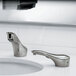 A Bobrick polished nickel counter-mounted automatic faucet over a bathroom sink.