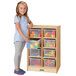A girl standing next to a Jonti-Craft wooden storage cabinet with cubbies.