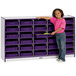 A young girl standing next to a purple and white Rainbow Accents classroom storage unit.