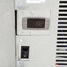 A digital display on a control panel inside a Norlake Kold Locker with a metal door.
