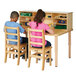 A boy and a girl sitting at a Jonti-Craft children's work table with chairs.