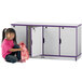 A young girl in a pink shirt sitting next to a Rainbow Accents purple and gray locker with a pink backpack.