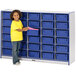 A young girl standing next to a Rainbow Accents blue storage cabinet with blue tubs.