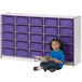A young girl sitting on the floor reading a book in front of a purple Rainbow Accents storage unit.