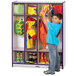 A young boy in a blue shirt putting clothes in a purple Rainbow Accents coat locker.