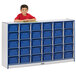 A young boy leaning on a Rainbow Accents blue storage cabinet with blue trays.