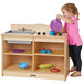 A girl playing with a Jonti-Craft toddler kitchen set.