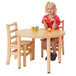 A girl sitting at a Jonti-Craft Baltic Birch adjustable height table with toys.