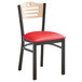 A Lancaster Table & Seating black metal bistro chair with a red cushion.