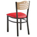 A Lancaster Table & Seating black metal bistro chair with red vinyl seat.