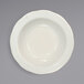 An International Tableware ivory stoneware bowl with a scalloped rim.