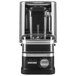 A black and silver KitchenAid commercial blender with enclosure and a black jar on top.