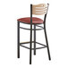 A Lancaster Table & Seating Bistro Bar Stool with a red vinyl seat and natural wood back on a black frame.