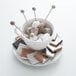 A white Arcoroc saucer holding a cup of coffee with marshmallows and a stick of cane sugar.