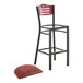 A black Lancaster Table & Seating bistro bar stool with a burgundy cushion and mahogany wood back on a white surface.