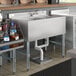 A Regency stainless steel underbar sink with left drainboard on a counter in a cocktail bar.