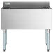 A Regency stainless steel underbar ice bin with bottle holders on a counter.