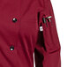 A Uncommon Chef long sleeve burgundy chef coat with 10 buttons on a counter.
