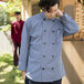 A man in a Uncommon Chef long sleeve chef coat with 10 buttons in a professional kitchen.