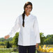 A woman wearing a white Uncommon Chef long sleeve chef coat with 10 buttons.