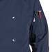 A navy blue Uncommon Chef long sleeve chef coat with 10 red buttons.