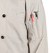 A Uncommon Chef long sleeve chef coat with red buttons and a pocket.