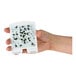 A hand holding a DynaTrap StickyTech glue card with flies on it.