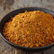 A bowl of McCormick Grill Mates Brown Sugar Bourbon seasoning on a wood surface.