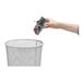 A hand holding a Victor Pest Power-Kill Rat Trap over a trash can.
