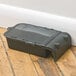 A grey plastic Victor Pest mouse trap box on a wood floor.