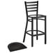 A Lancaster Table & Seating black ladder back bar stool with black wood seat.