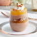 A Visions clear plastic stemless wine glass filled with a dessert with chocolate and coconut.