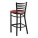 A Lancaster Table & Seating black ladder back bar stool with a burgundy padded seat.