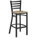 A Lancaster Table & Seating black and wood ladder back bar stool with a driftwood seat.