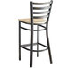 A black metal Lancaster Table & Seating bar stool with a wood seat and back.