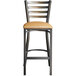 A Lancaster Table & Seating metal bar stool with a light brown cushion.