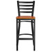 A black Lancaster Table & Seating Ladder Back Bar Stool with a cherry wood seat.