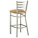 A Lancaster Table & Seating metal bar stool with a tan seat.