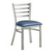 A Lancaster Table & Seating metal chair with a navy vinyl cushion on the seat and ladder back.