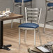 A Lancaster Table & Seating Ladder Back chair with a navy blue cushion on a table.