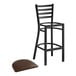A Lancaster Table & Seating black ladder back bar stool with dark brown vinyl padded seat.