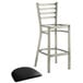 A Lancaster Table & Seating metal ladder back bar stool with a black vinyl padded seat.