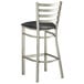 A Lancaster Table & Seating ladder back bar stool with a black vinyl padded seat.