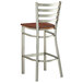 A Lancaster Table & Seating metal ladder back bar stool with a wood seat.