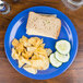 A Carlisle Ocean Blue melamine plate with a sandwich and chips.
