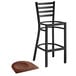 A Lancaster Table & Seating black metal bar stool with an antique walnut wood seat.