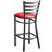 A Lancaster Table & Seating distressed copper metal ladder back bar stool with a red vinyl padded seat.